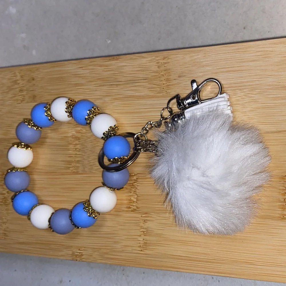 Blue and white bracelet keychain with white pom-pom